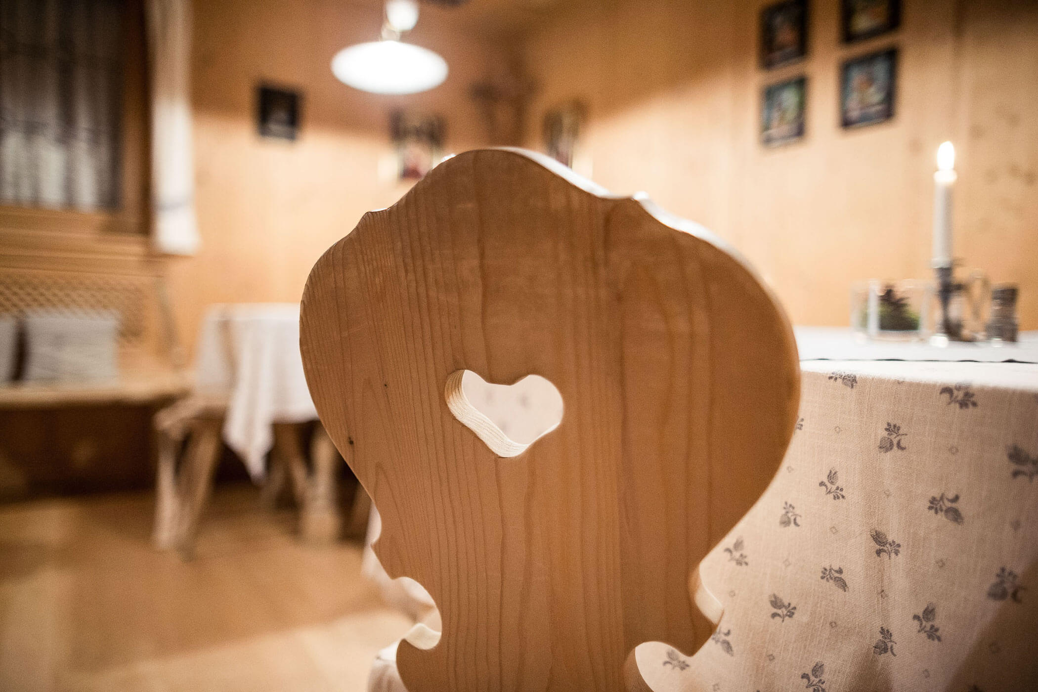 Nahaufnahme eines Holzstuhls mit ausgeschnittenem Herz - Hotel Alpenhof
