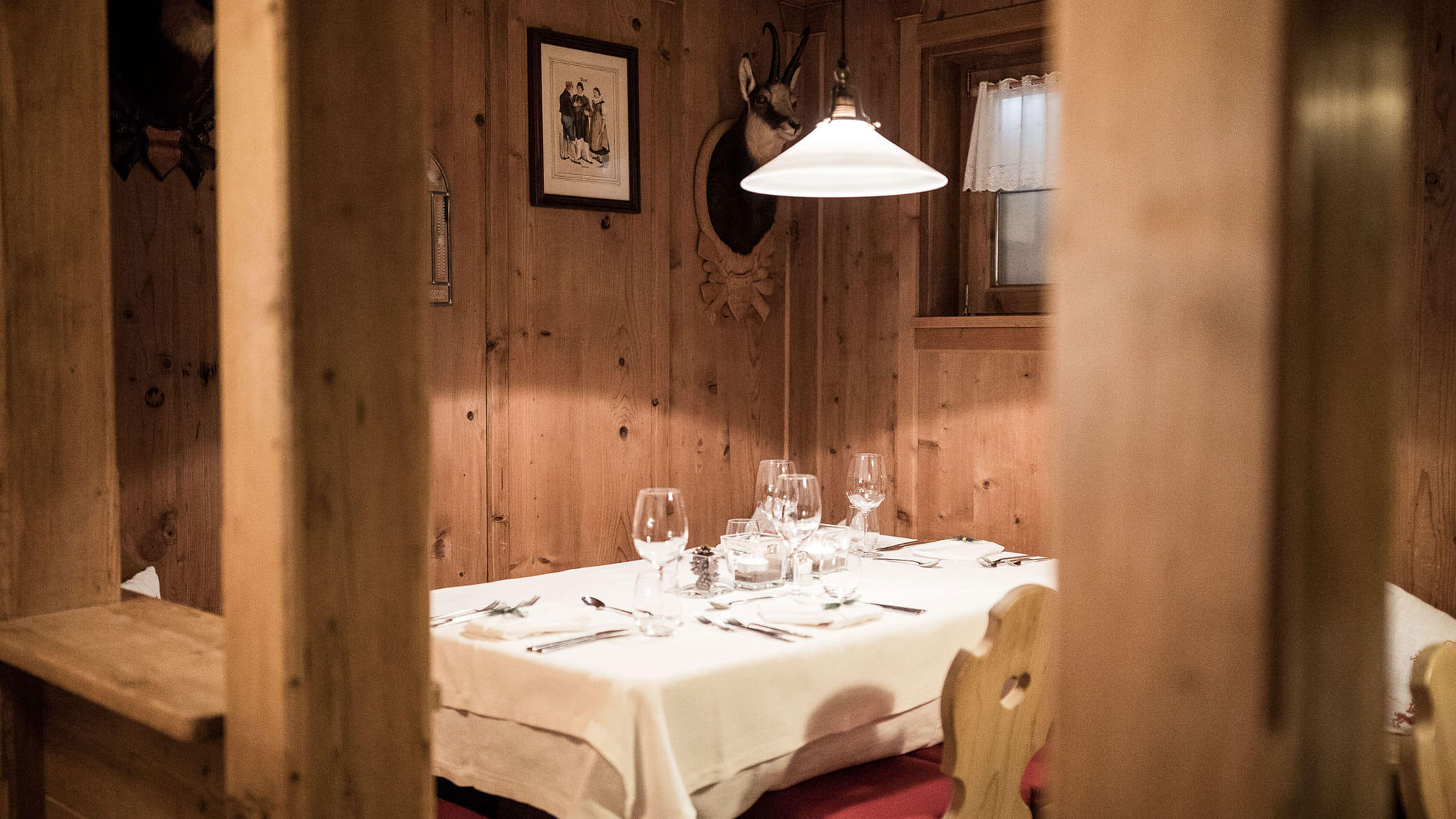 Gedeckter Tisch im Speisesaal mit Gläsern, Besteck und Servietten - Hotel Alpenhof