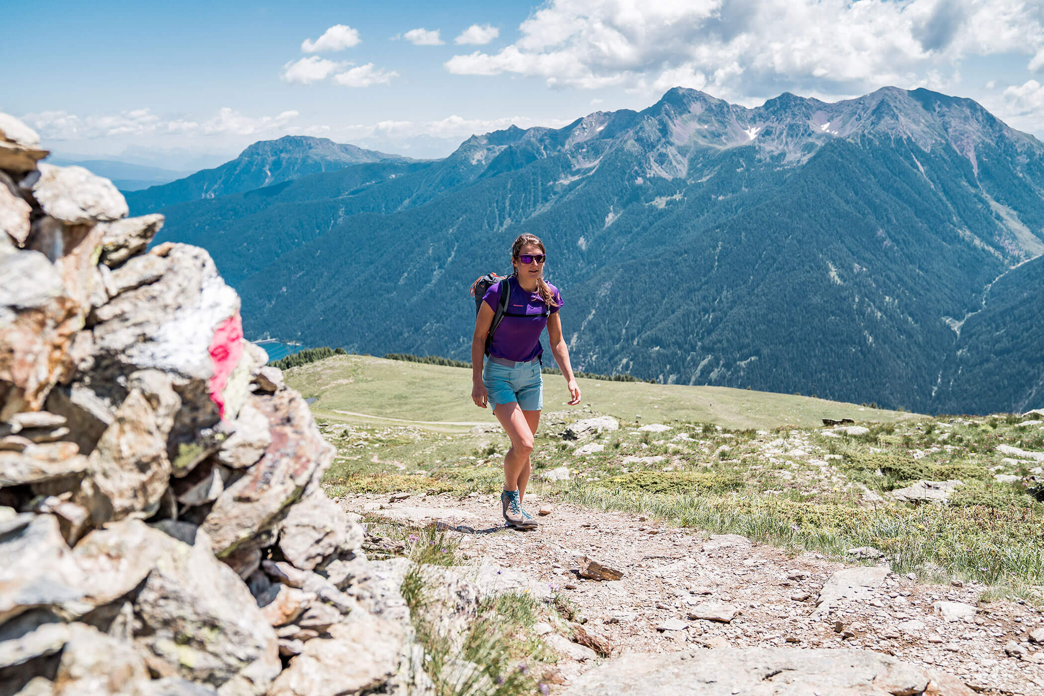 Ein Frau spaziert auf dem Wanderweg zwischen den Südtiroler Bergen - Hotel Alpenhof